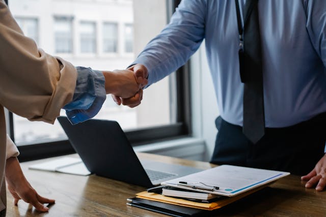 two business people shaking hands after reaching a formal agreement