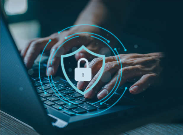 A person typing on a laptop with a digital shield and a lock inside of the shield.