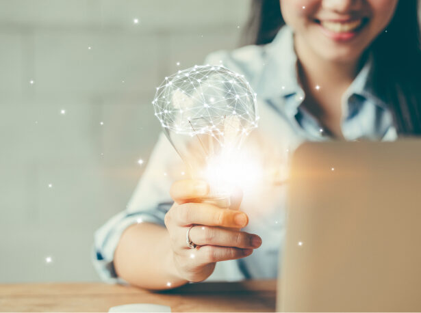 A person holding a lightbulb, symbolizing intellectual property.